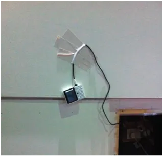 A photo of a smart phone duct taped to a wall