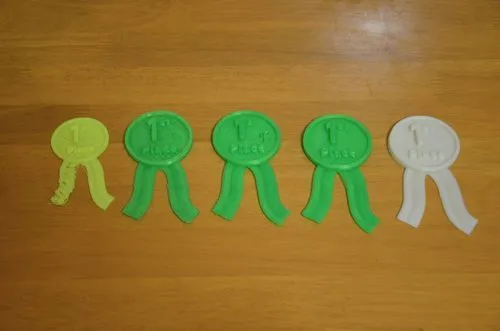 A photo showing the evolution of a 3D printed prize ribbon design