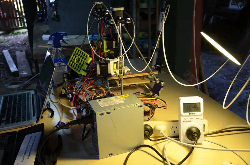 A photo of a RepRap 3D printer plugged into a kill-a-watt style power meter.
