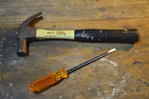 A photo of a hammer and a flathead screwdriver