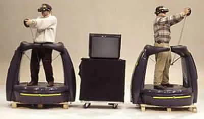 A photo of two people in the dactyl nightmare VR system