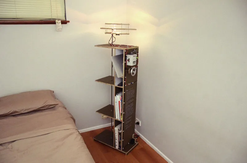 A combination floor lamp, book case, bedside table and charging station.