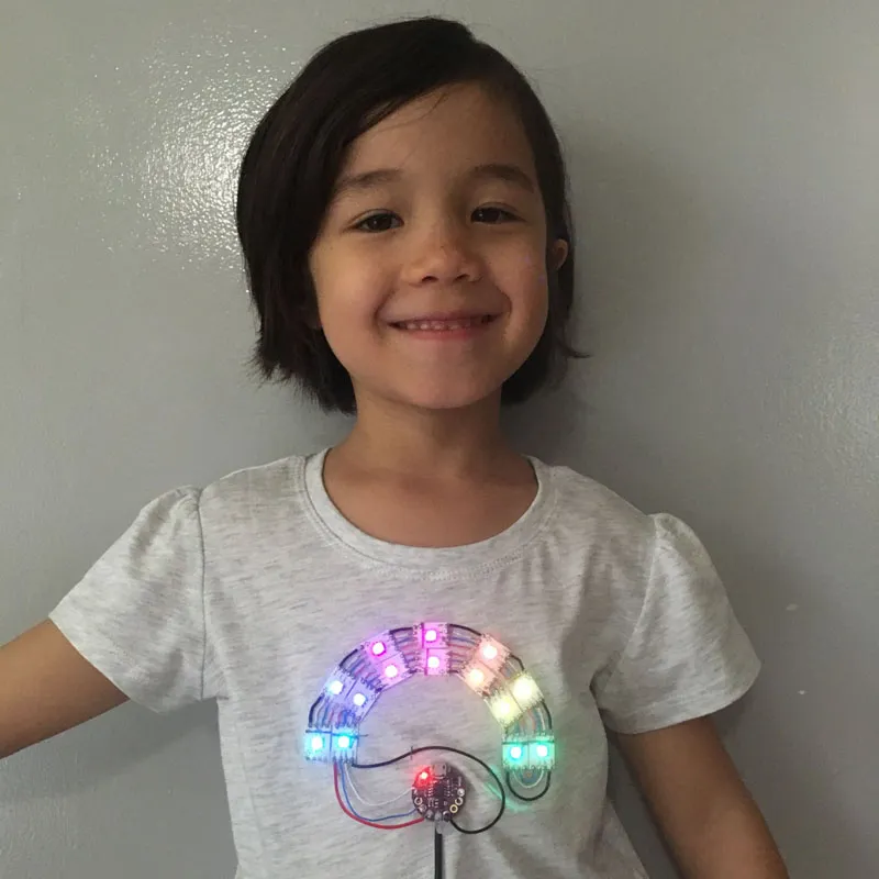 A t-shirt with a LED strip in the shape of a raibow. The Light emmiting diodes cycle through the colours of the rainbow.