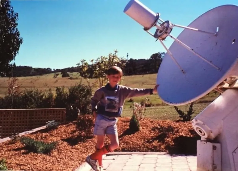 A photo of me standing next to a communication dish at Tidbinbilla.